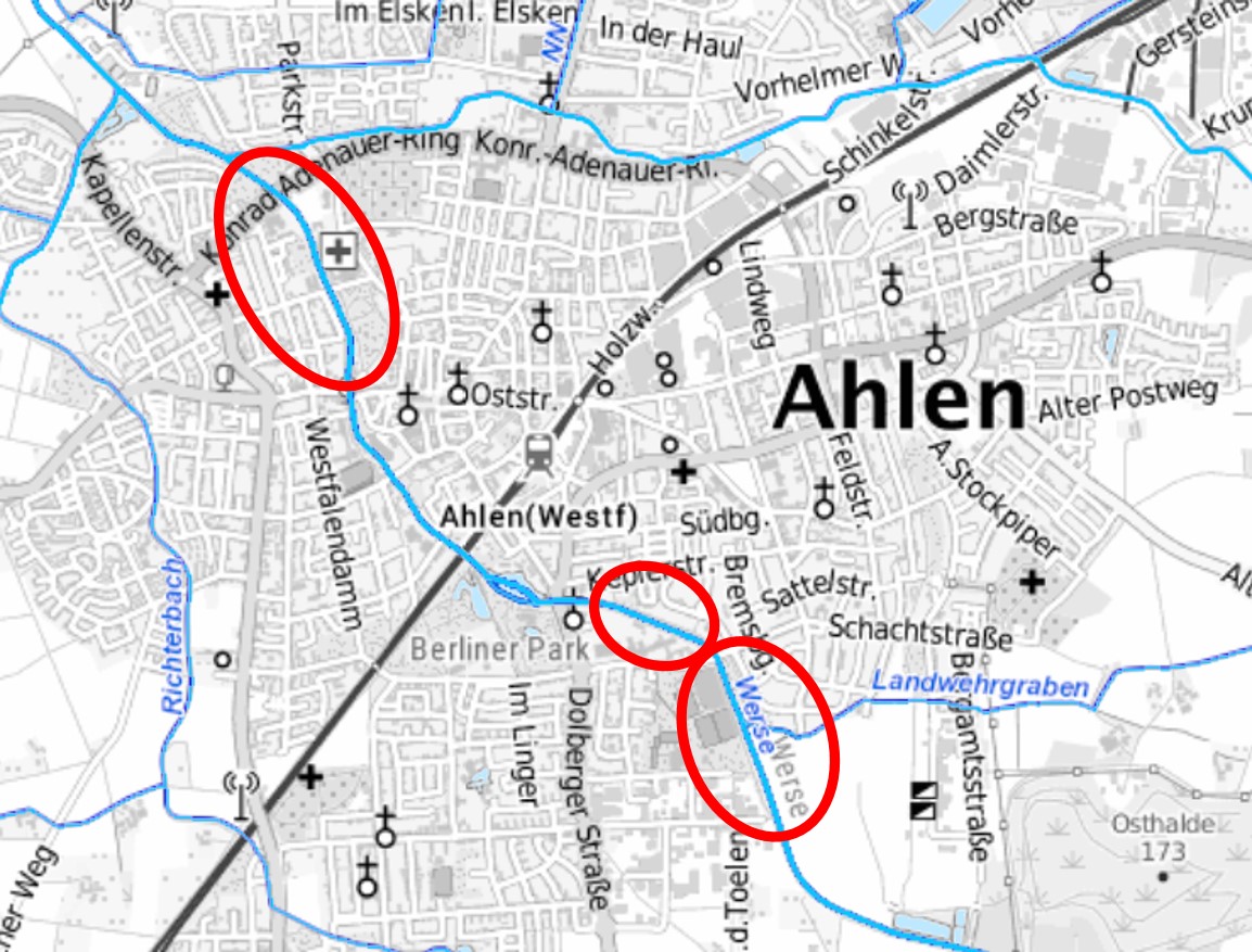 Auf einem schwarz-weißen Plan ist Ahlen zu sehen. Mehrere Gewässer sind in Blau eingezeichnet. Diagonal von rechts unten nach links oben verläuft die Werse. Eine schwarze Kennzeichnung für die Bahnlinie verläuft von links unten nach rechts oben. Südlich der Bahnlinie sind 2 aneinandergrenzende rote Kreismarkierungen an der Werse eingezeichnet, nördlich der Bahnlinie ist ein Bereich an der Werse eingekreist.